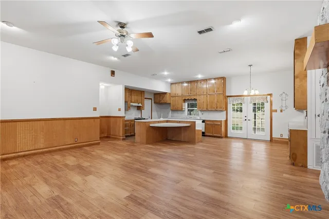 a kitchen with stainless steel appliances granite countertop a sink a stove a refrigerator a washer dryer and white cabinets