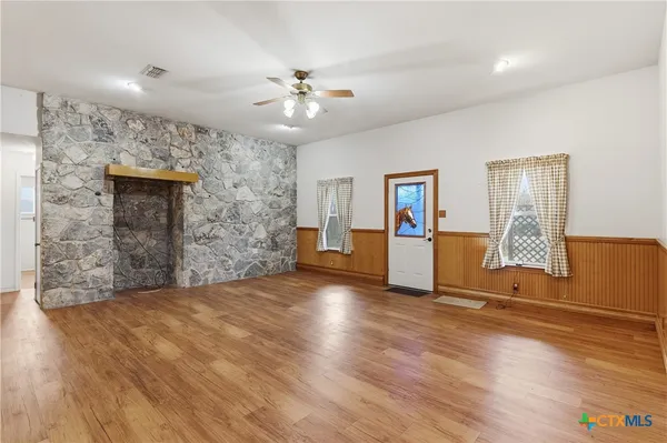 a view of a livingroom with wooden floor and a ceiling fan