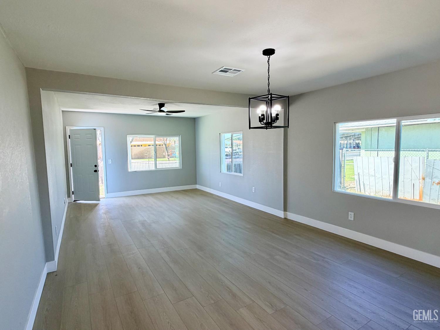 Undisclosed Address Wasco, CA 93280 - Photo 5 of 21 a view of an empty room with window and wooden floor