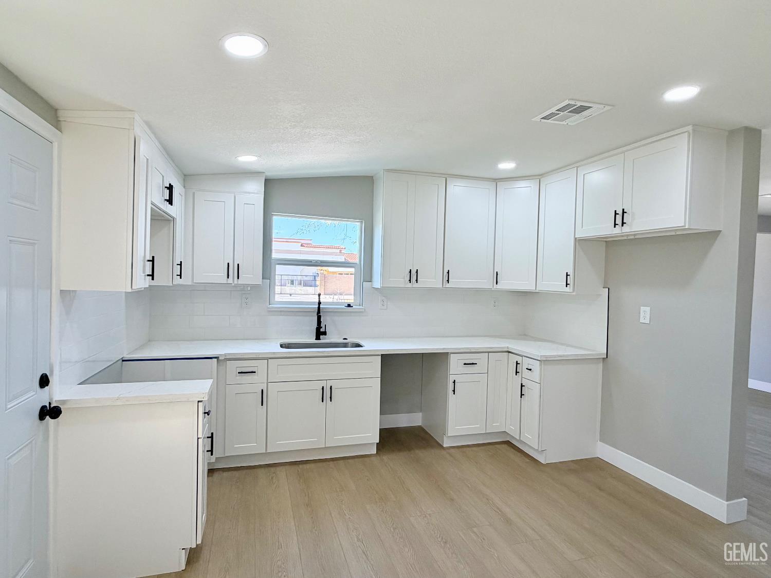 Undisclosed Address Wasco, CA 93280 - Photo 7 of 21 a kitchen with white cabinets appliances and sink