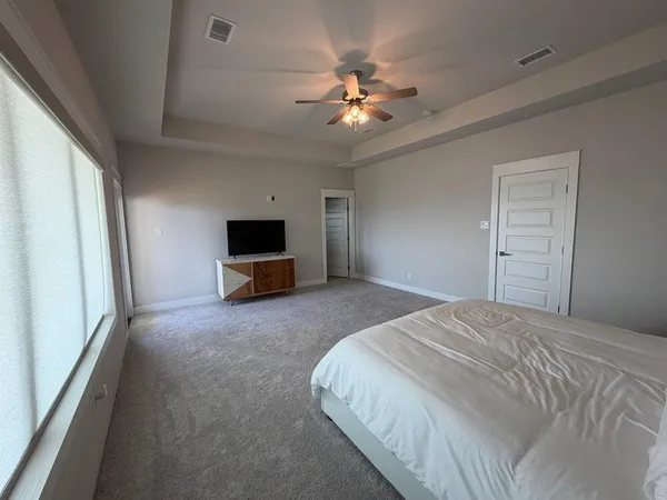 a spacious bedroom with a bed and a chandelier