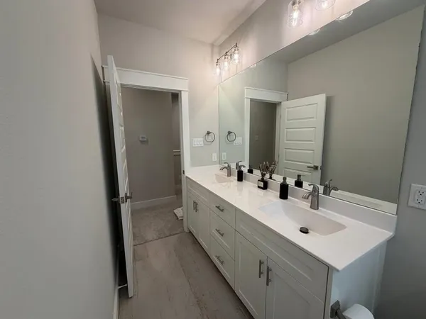 a bathroom with a sink double vanity granite tub and shower