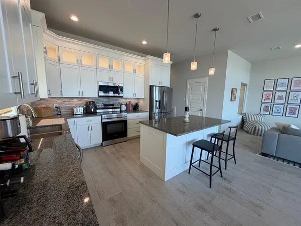 a kitchen with refrigerator a microwave a stove and a center island