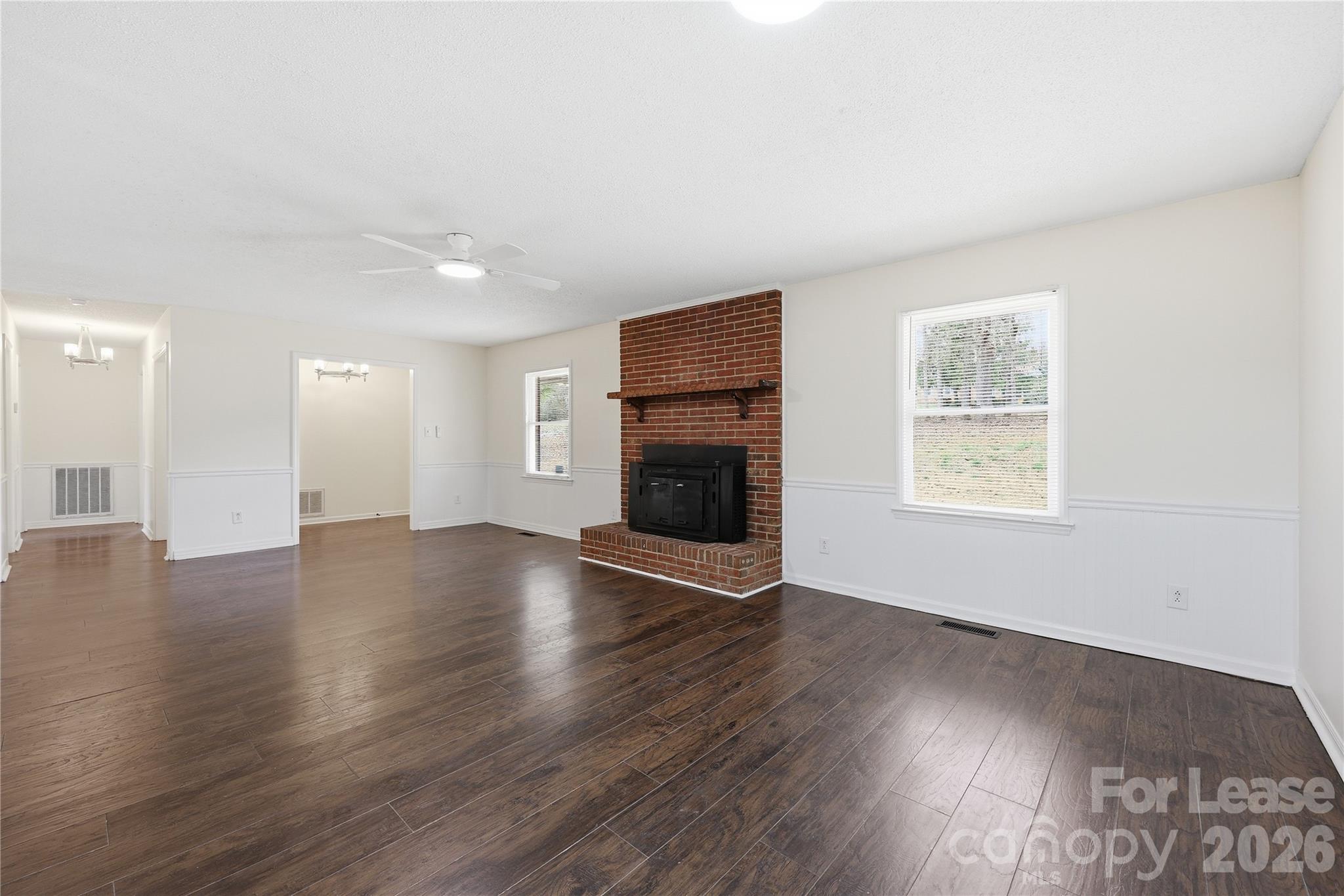224 Yamasee Road Waxhaw, NC 28173 - Photo 4 of 22 an empty room with wooden floor and fireplace