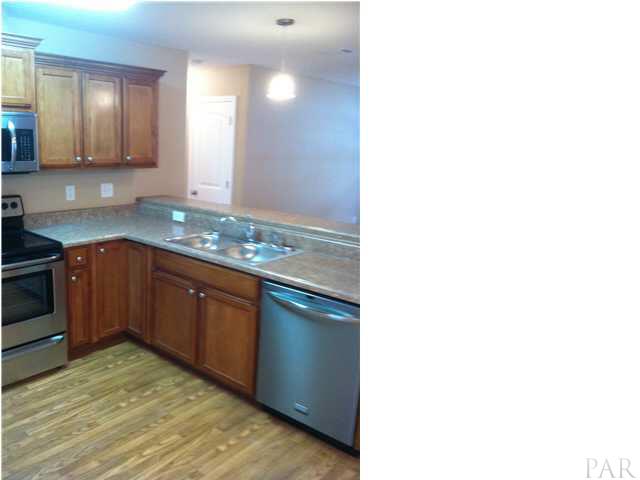 4680 Old Guernsey Road Pace, FL 32571 - Photo 3 of 6 a kitchen with stainless steel appliances granite countertop a sink and cabinets