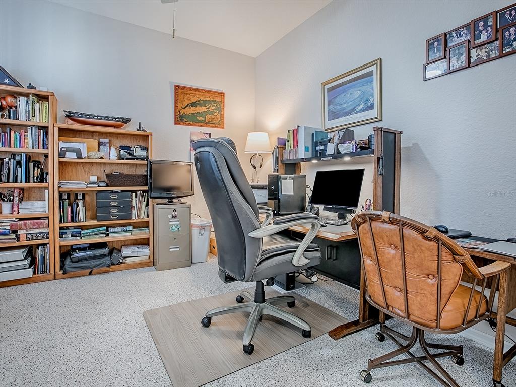 13324 Southeast 91st Court Road Summerfield, FL 34491 - Photo 16 of 46 a view of a workspace with furniture and a bookshelf