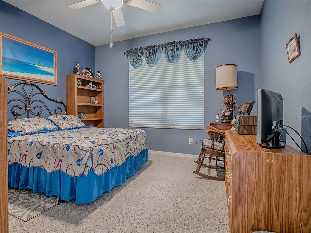 13324 Southeast 91st Court Road Summerfield, FL 34491 - Photo 18 of 46 a bedroom with a bed a mirror and desk