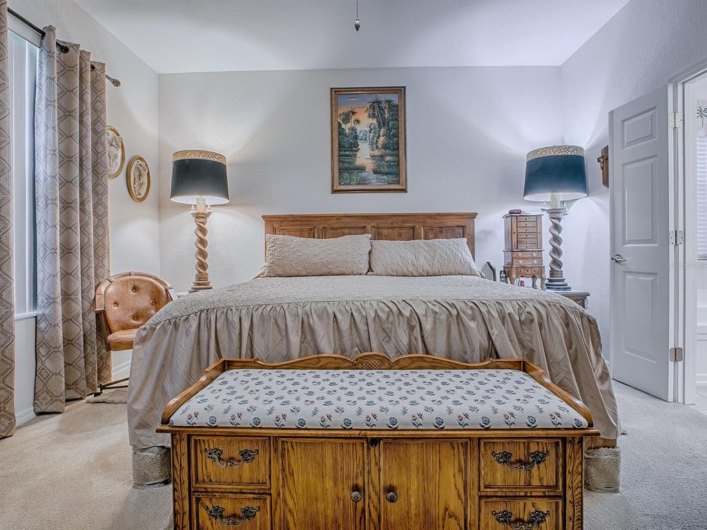 13324 Southeast 91st Court Road Summerfield, FL 34491 - Photo 20 of 46 a bedroom with a bed and painting on the wall