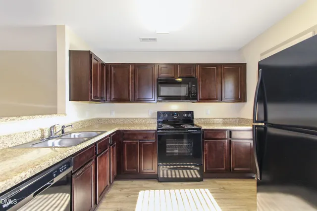a kitchen with stainless steel appliances granite countertop a stove a sink dishwasher and a refrigerator