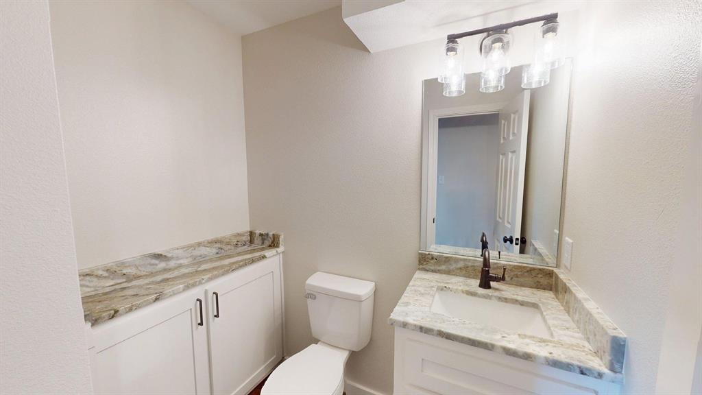 1110 Mill Run Road Athens, TX 75751 - Photo 16 of 32 a bathroom with a granite countertop sink and a toilet