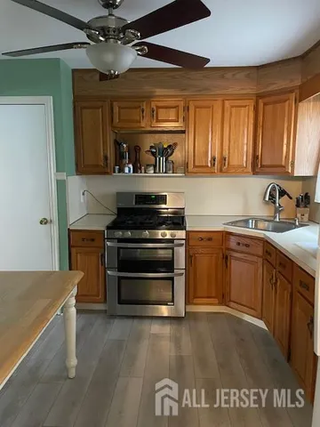 a kitchen with kitchen island a sink a stove cabinets and wooden floor