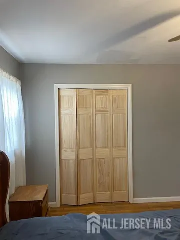 a bedroom with a bed and a flat tv screen on dresser