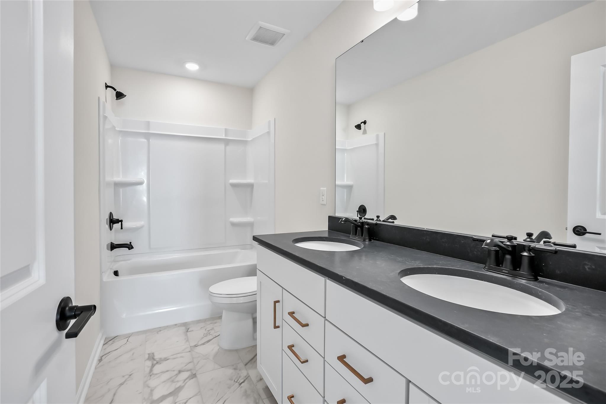 1821 Riverbend Avenue, Unit 85 Monroe, NC 28110 - Photo 15 of 15 a bathroom with a granite countertop sink toilet a mirror and shower