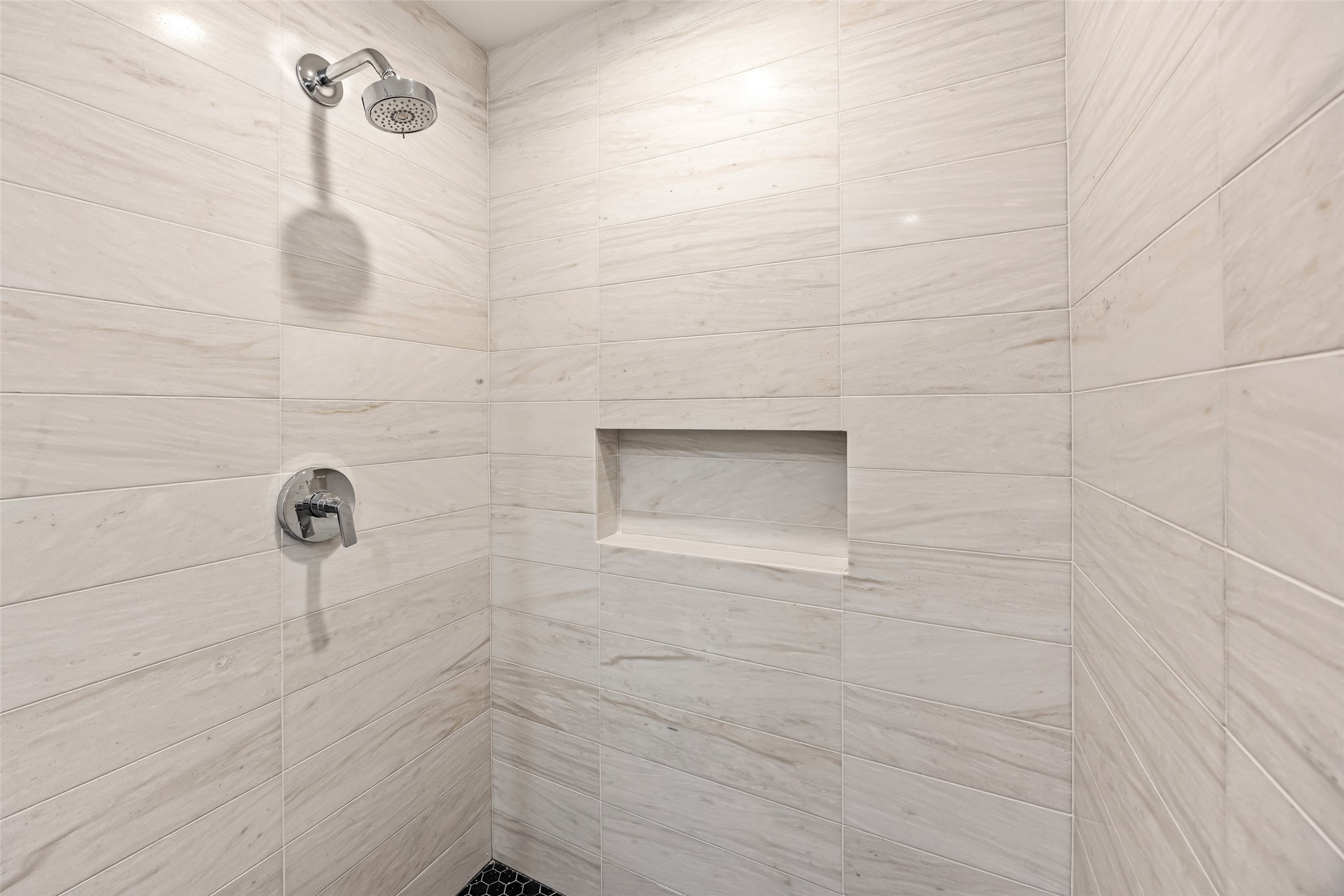 5658 Del Monte Drive Houston, TX 77056 - Photo 17 of 35 The double vanity features custom cabinetry, slab countertops, elegant sconce lighting, and abundant storage—including a central tower for everyday convenience. The suite continues into an expansive, fully built-out walk-in closet with adjustable shelving, drawers, and generous hanging space, designed to accommodate even the most extensive wardrobe.
This entire wing of the home feels like stepping into a modern boutique hotel—private, calming, and beautifully executed.