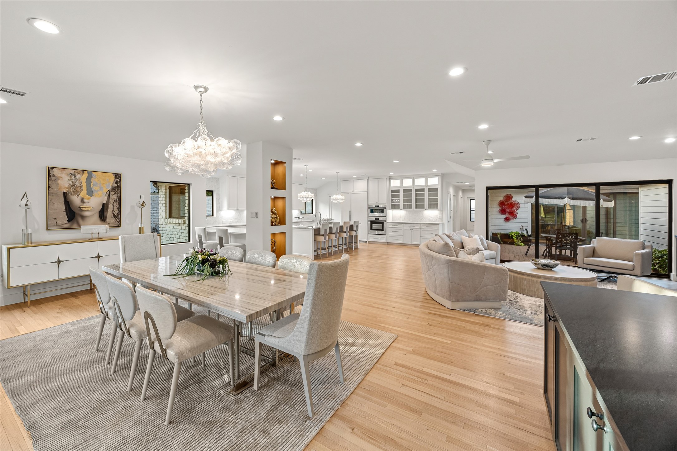 5658 Del Monte Drive Houston, TX 77056 - Photo 28 of 35 Expansive Open-Concept Living
This stunning open-concept layout seamlessly blends the dining, kitchen, and living areas, creating an elegant space ideal for both everyday living and entertaining. Flooded with natural light, the room features wide-plank hardwood floors, designer lighting, custom cabinetry, and floor-to-ceiling windows overlooking the private courtyard. A chef’s kitchen anchors the space with an oversized island and luxury finishes, offering effortless flow throughout the home.