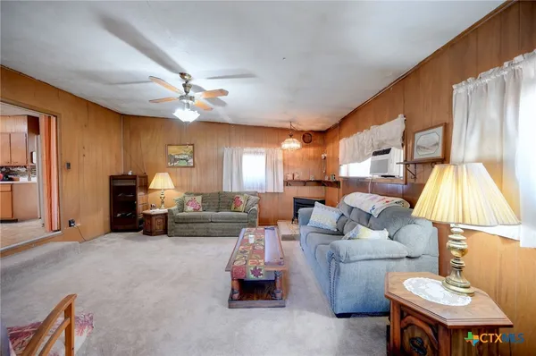 a living room with furniture a chandelier and a flat screen tv