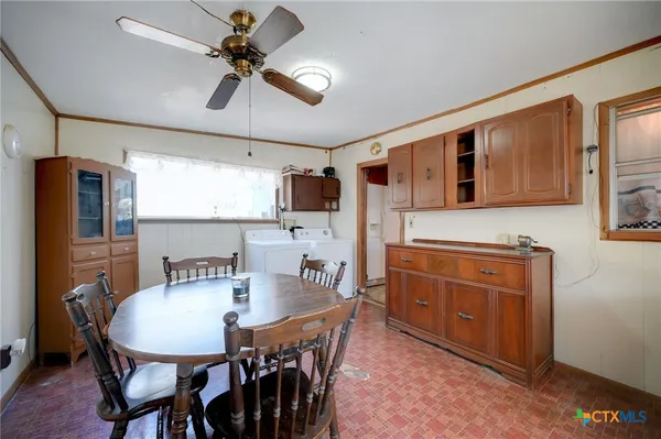 a kitchen with stainless steel appliances granite countertop a stove a refrigerator a kitchen island a dining table and chairs with wooden floor