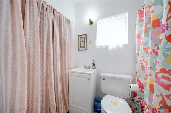 a white toilet sitting next to a shower curtain