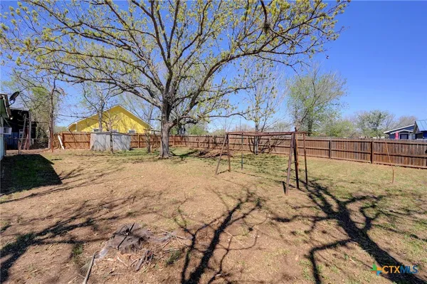 a view of tall trees with wooden fence