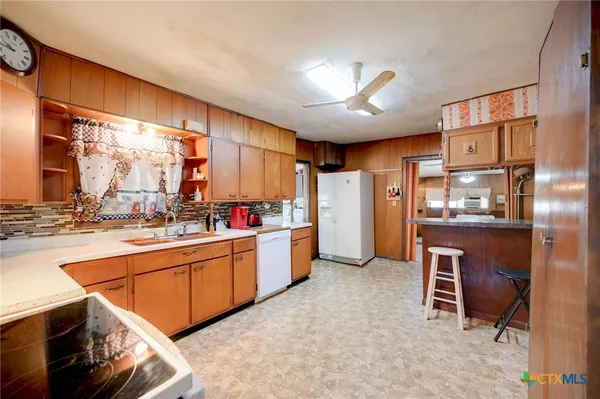 a kitchen with stainless steel appliances granite countertop a refrigerator and a stove top oven