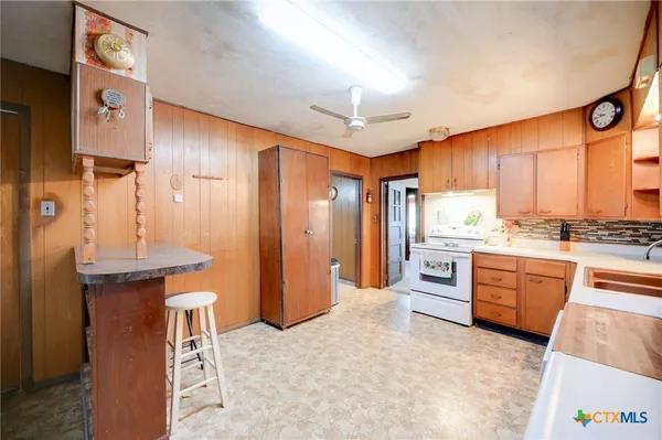 a large kitchen with stainless steel appliances kitchen island granite countertop a refrigerator and a stove top oven