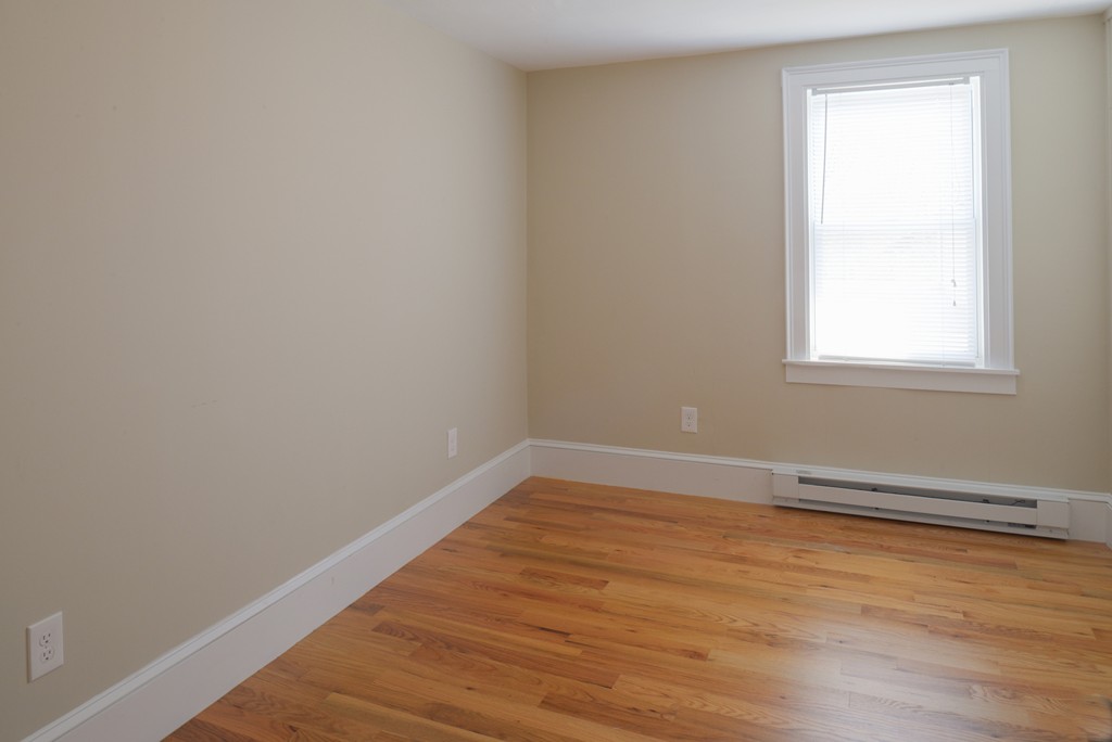 62 Eastern Point Road, Unit 1 Gloucester, MA 01930 - Photo 13 of 20 an empty room with wooden floor and windows