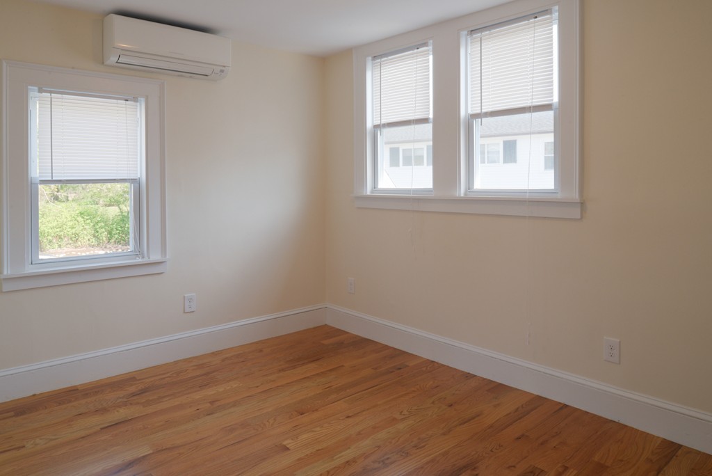 62 Eastern Point Road, Unit 1 Gloucester, MA 01930 - Photo 14 of 20 an empty room with wooden floor and windows