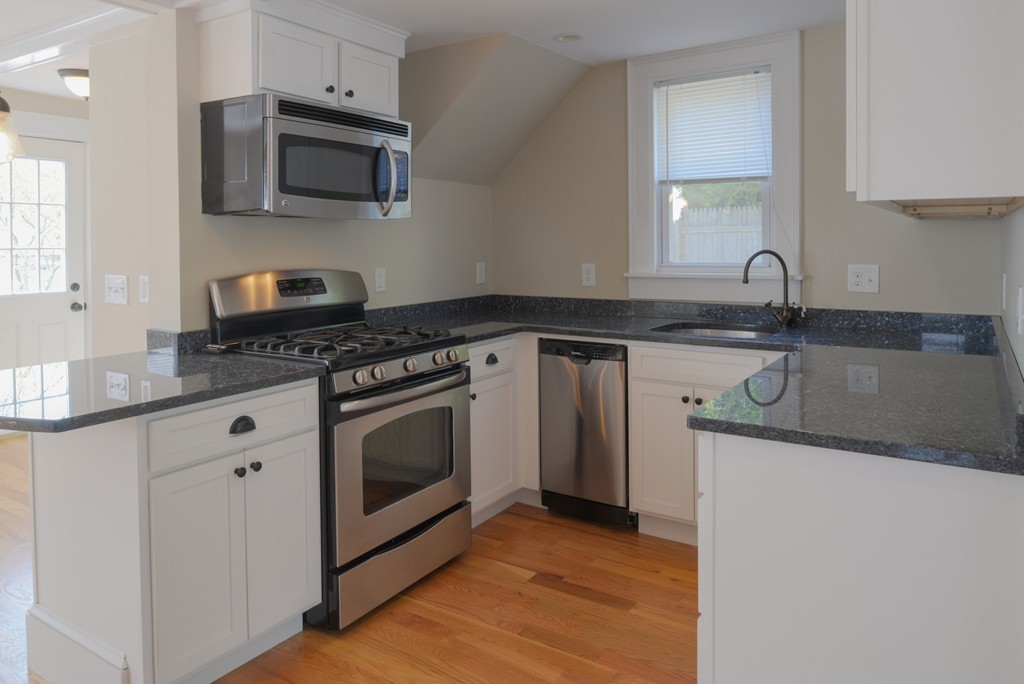 62 Eastern Point Road, Unit 1 Gloucester, MA 01930 - Photo 2 of 20 a kitchen with stainless steel appliances granite countertop a stove a sink and a microwave