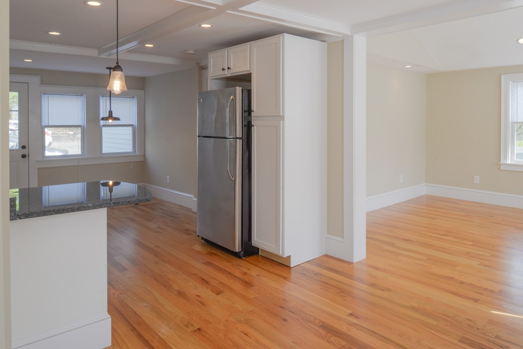 62 Eastern Point Road, Unit 1 Gloucester, MA 01930 - Photo 4 of 20 a view of a kitchen cabinets a wooden floor and a window