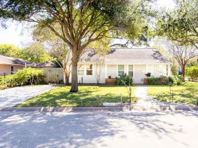 a view of house with outdoor space and trees in the background