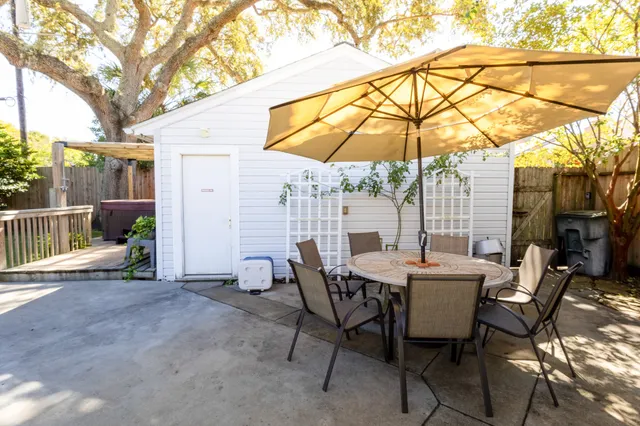 a view of a patio with table and chairs under an umbrella