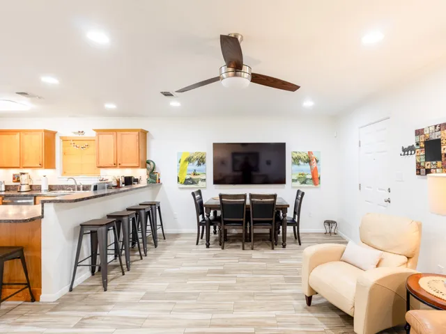 a kitchen with stainless steel appliances granite countertop a stove top oven a sink a dining table and chairs