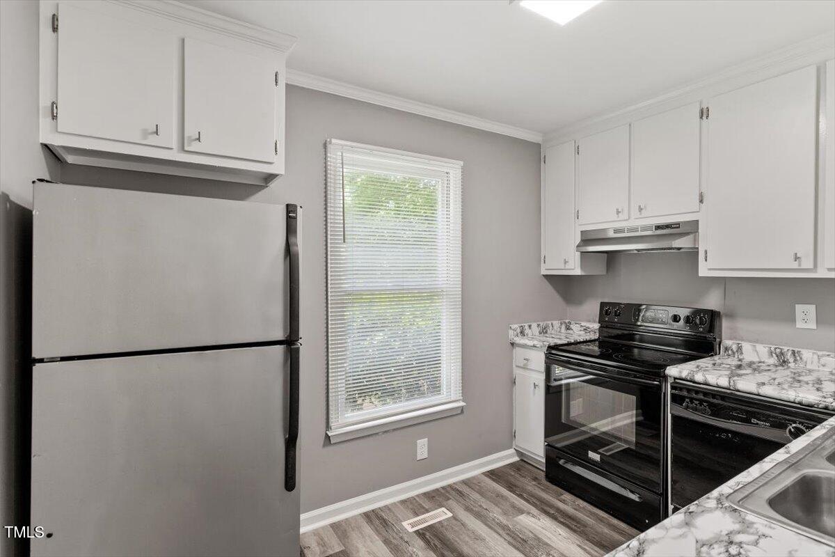 9 Tarawa Terrace, Unit A Durham, NC 27705 - Photo 5 of 12 a kitchen with stainless steel appliances granite countertop a refrigerator sink and cabinets