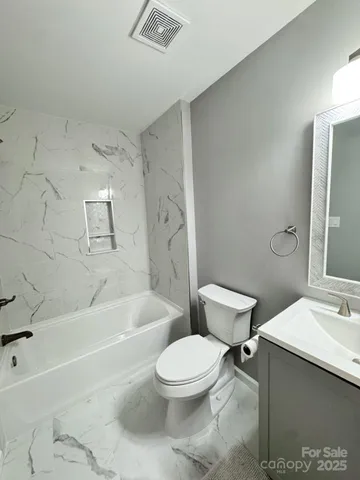 a bathroom with a toilet a sink and bathtub