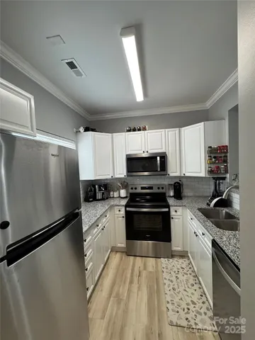 a kitchen with stainless steel appliances a refrigerator sink and stove