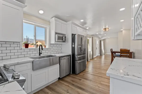 a kitchen with stainless steel appliances granite countertop a sink stove and refrigerator