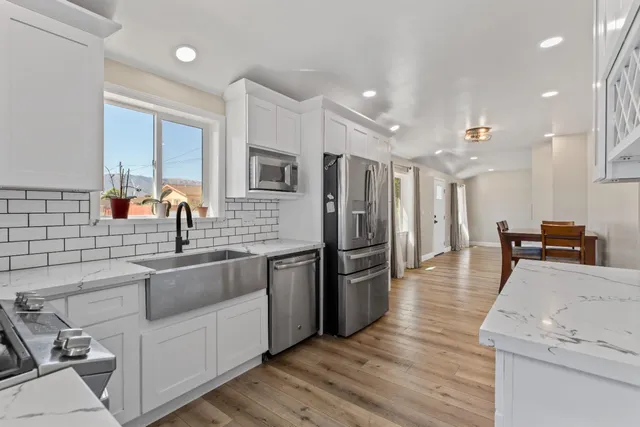 a kitchen with stainless steel appliances granite countertop a sink stove and refrigerator