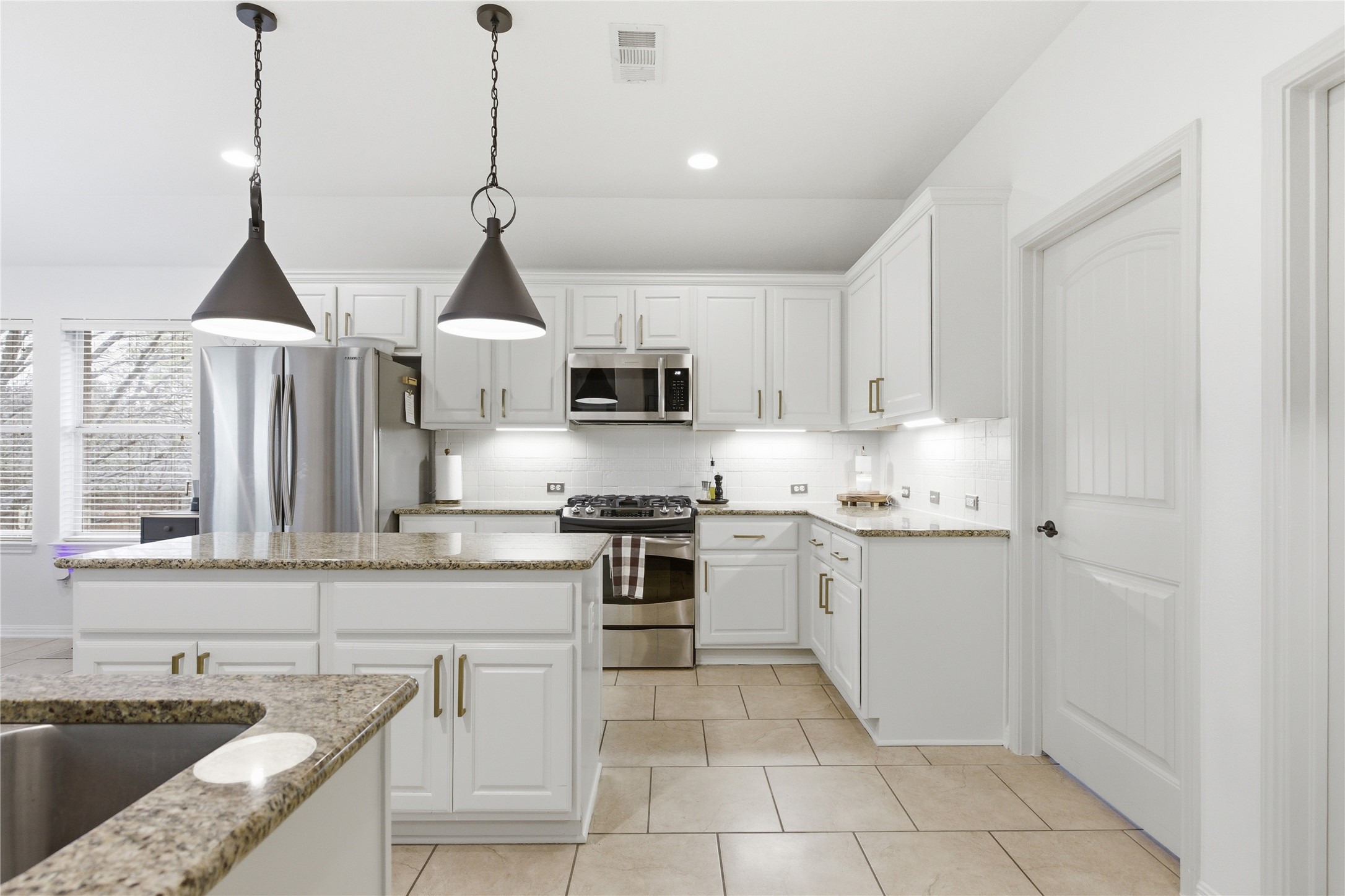 1312 Rimstone Drive Cedar Park, TX 78613 - Photo 7 of 25 a kitchen with stainless steel appliances granite countertop a sink and stove top oven