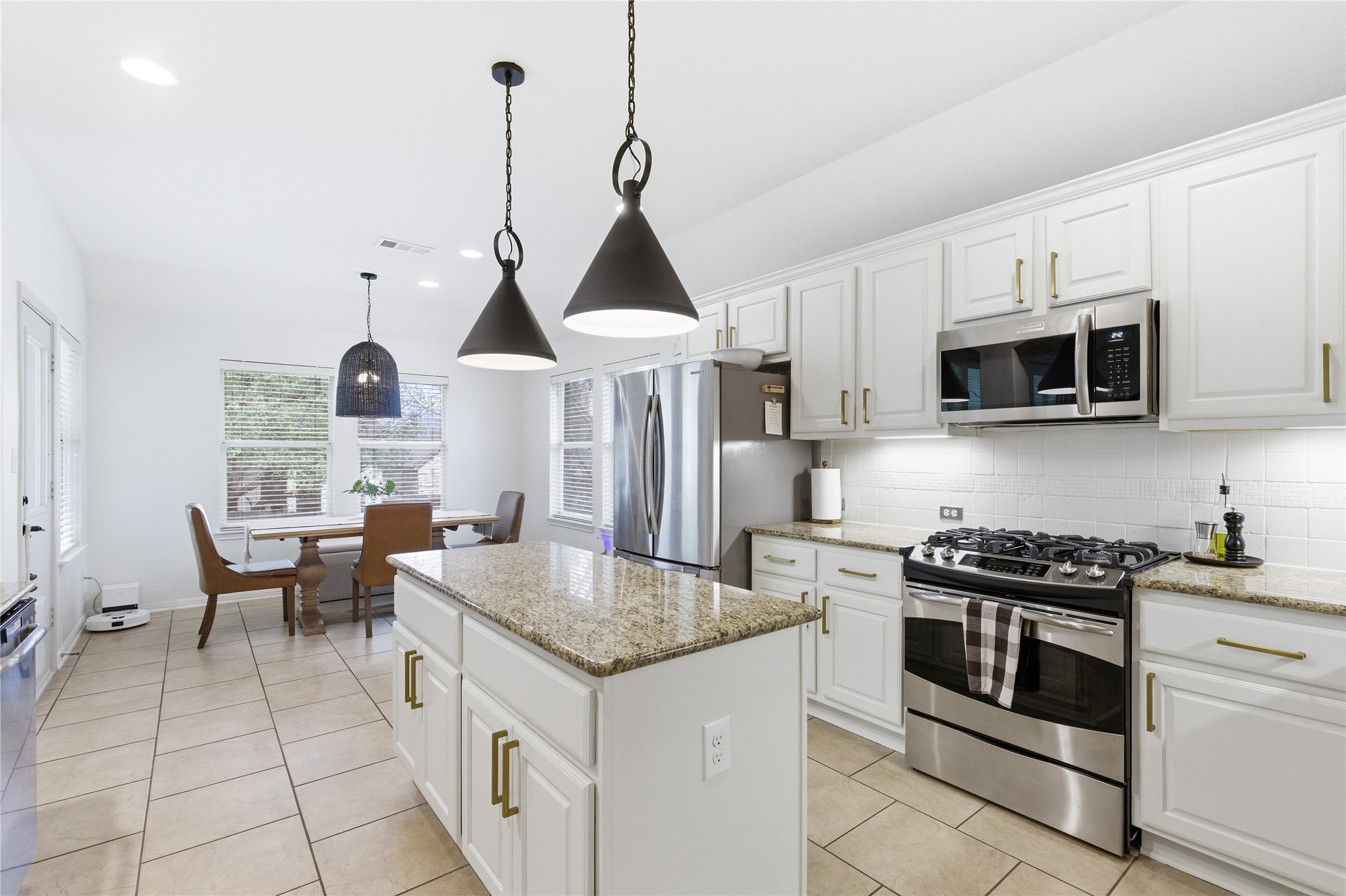1312 Rimstone Drive Cedar Park, TX 78613 - Photo 8 of 25 a kitchen with stainless steel appliances granite countertop a stove a sink and a microwave