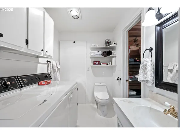 a bathroom with a sink toilet vanity and walk in closet