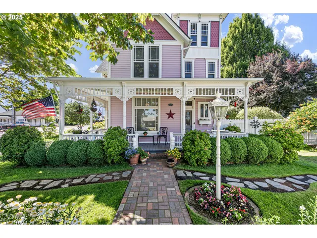 a view of a brick house with a yard and plants