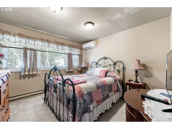 a bedroom with a bed next to a large window