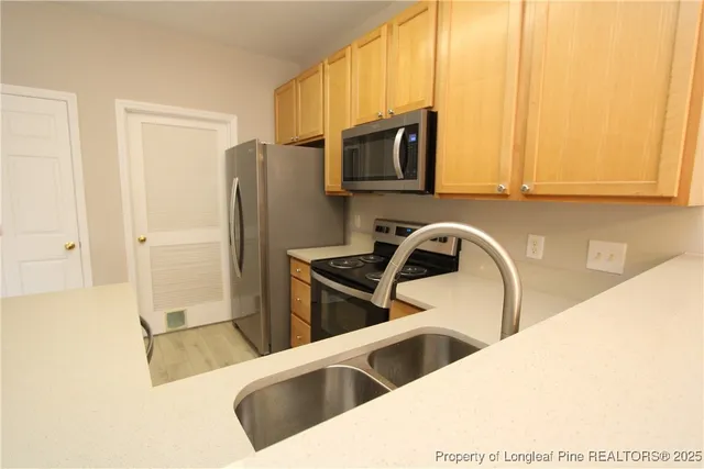 a kitchen with stainless steel appliances granite countertop a stove a sink and a microwave