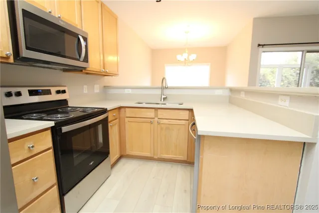a kitchen with stainless steel appliances a stove microwave and sink