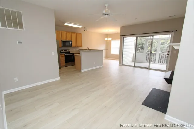 a view of a living room a kitchen with furniture and large windows