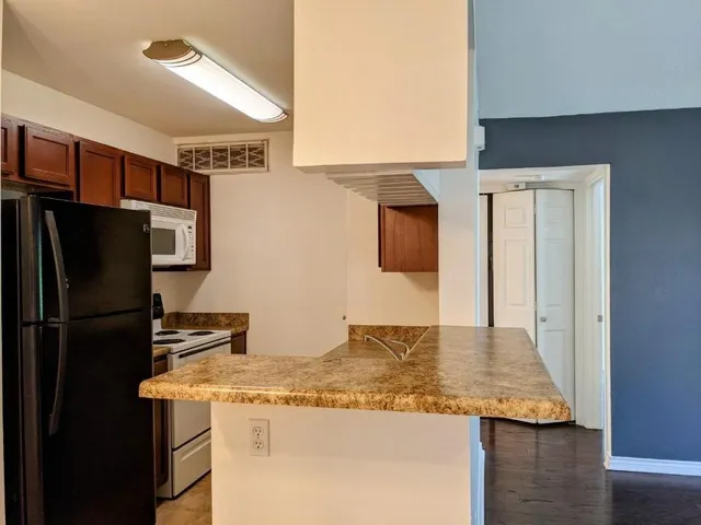 a kitchen with stainless steel appliances granite countertop a refrigerator and a stove