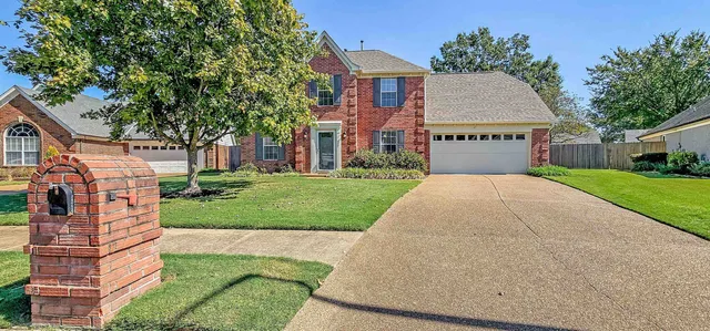 a view of a house with a yard and potted plants