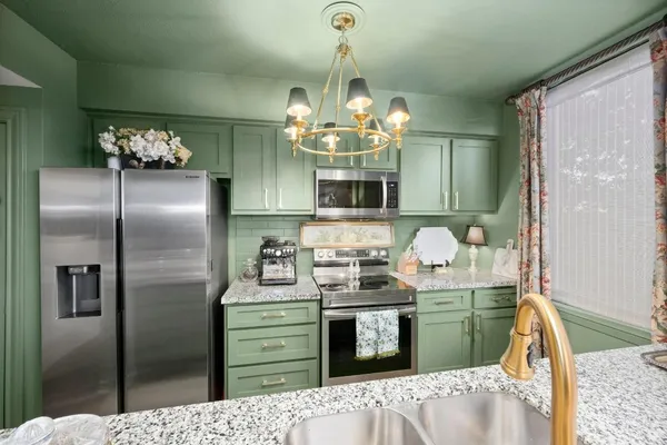 a kitchen with refrigerator a microwave and furniture