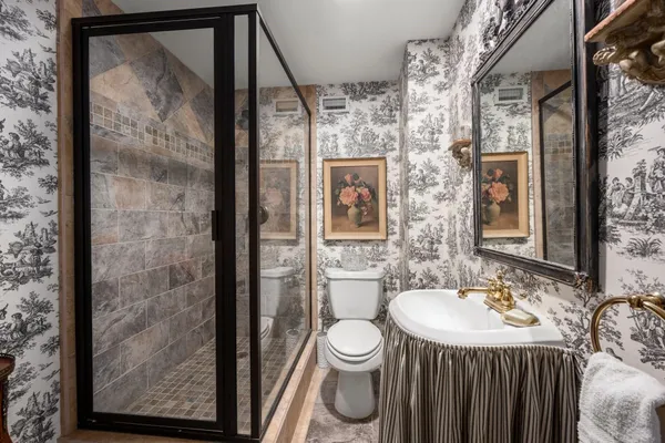 a bathroom with a sink a toilet and shower
