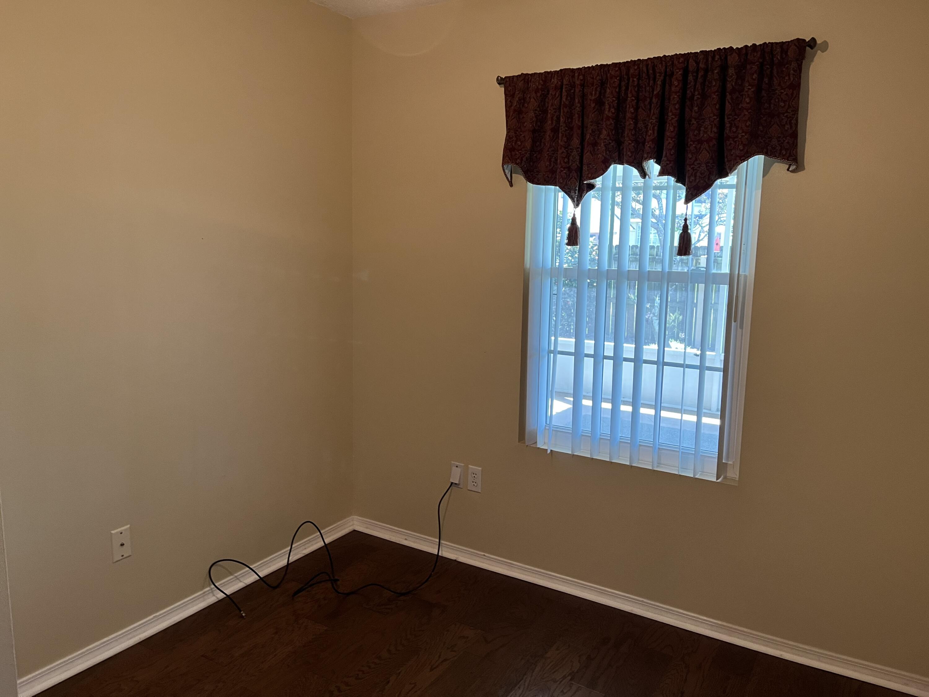2260 Estate Circle Navarre, FL 32566 - Photo 5 of 14 an empty room with a wooden floor and a potted plant